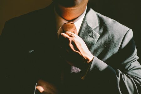 Why a Professional Staffing Service Will Help Your Company. Close up of man adjusting his tie